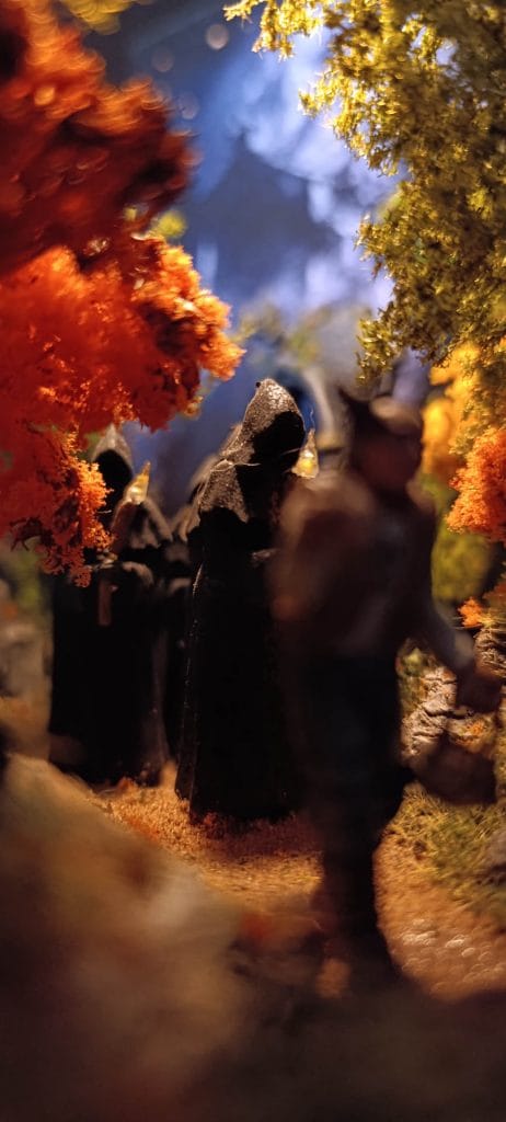 Diorama de la Santa Compaña: procesión de ánimas con túnicas negras y cirios iluminados en un bosque gallego