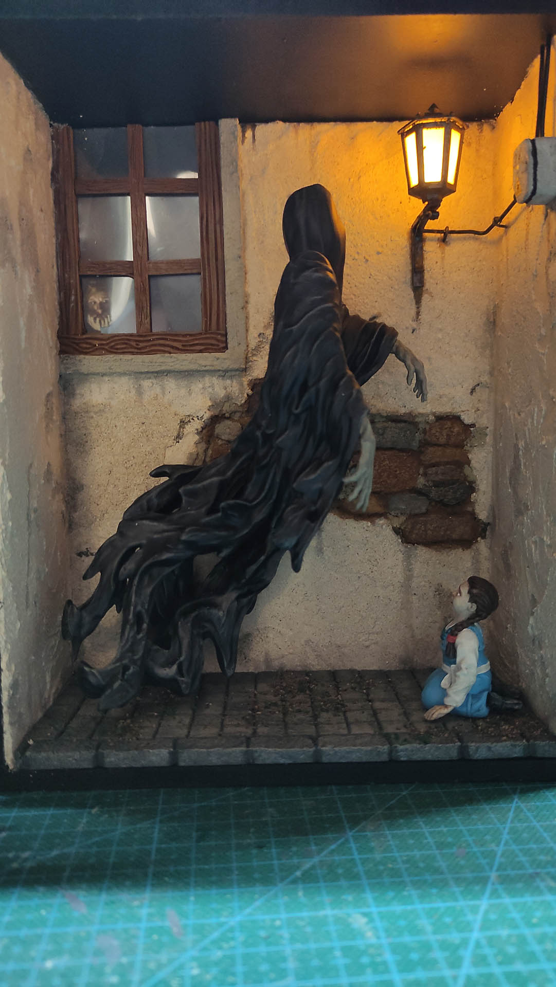 Diorama artesanal de "La Aparición de Saucedilla": escena de misterio y terror rural en miniatura con figuras detalladas, arquitectura antigua y atmósfera de leyenda