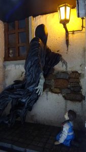 Diorama artesanal de "La Aparición de Saucedilla": escena de misterio y terror rural en miniatura con figuras detalladas, arquitectura antigua y atmósfera de leyenda