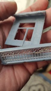 Diorama de una calle de París con fachadas de ladrillo, iluminación LED cálida y perspectiva forzada.