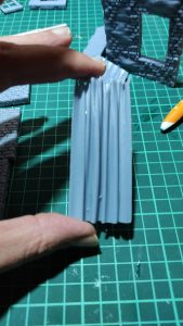 Diorama de una calle de París con fachadas de ladrillo, iluminación LED cálida y perspectiva forzada.