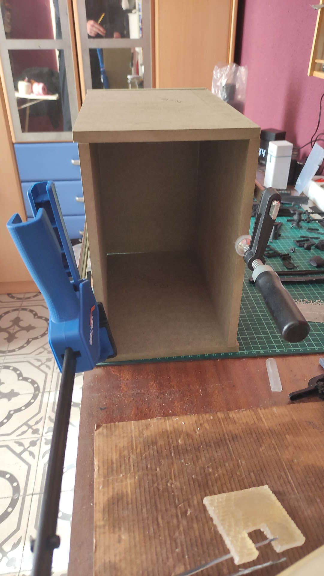 Diorama de una calle de París con fachadas de ladrillo, iluminación LED cálida y perspectiva forzada.