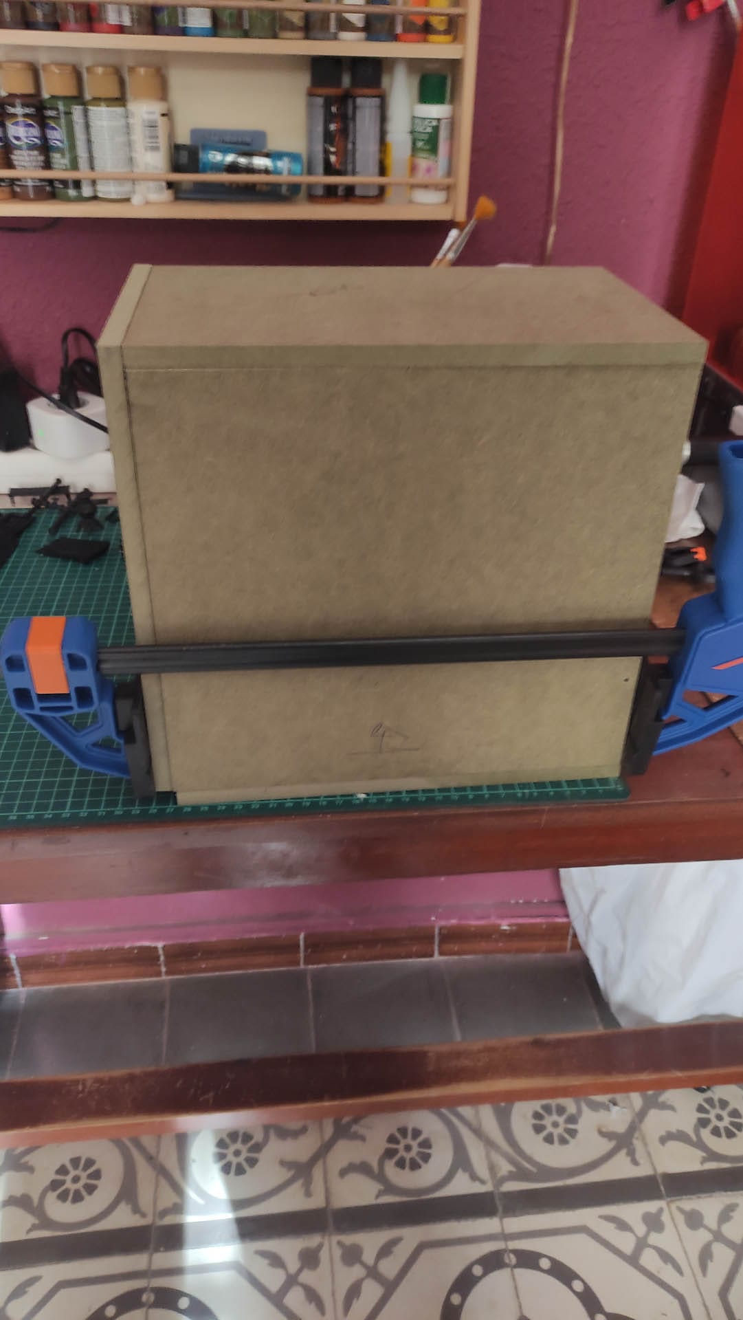 Diorama de una calle de París con fachadas de ladrillo, iluminación LED cálida y perspectiva forzada.