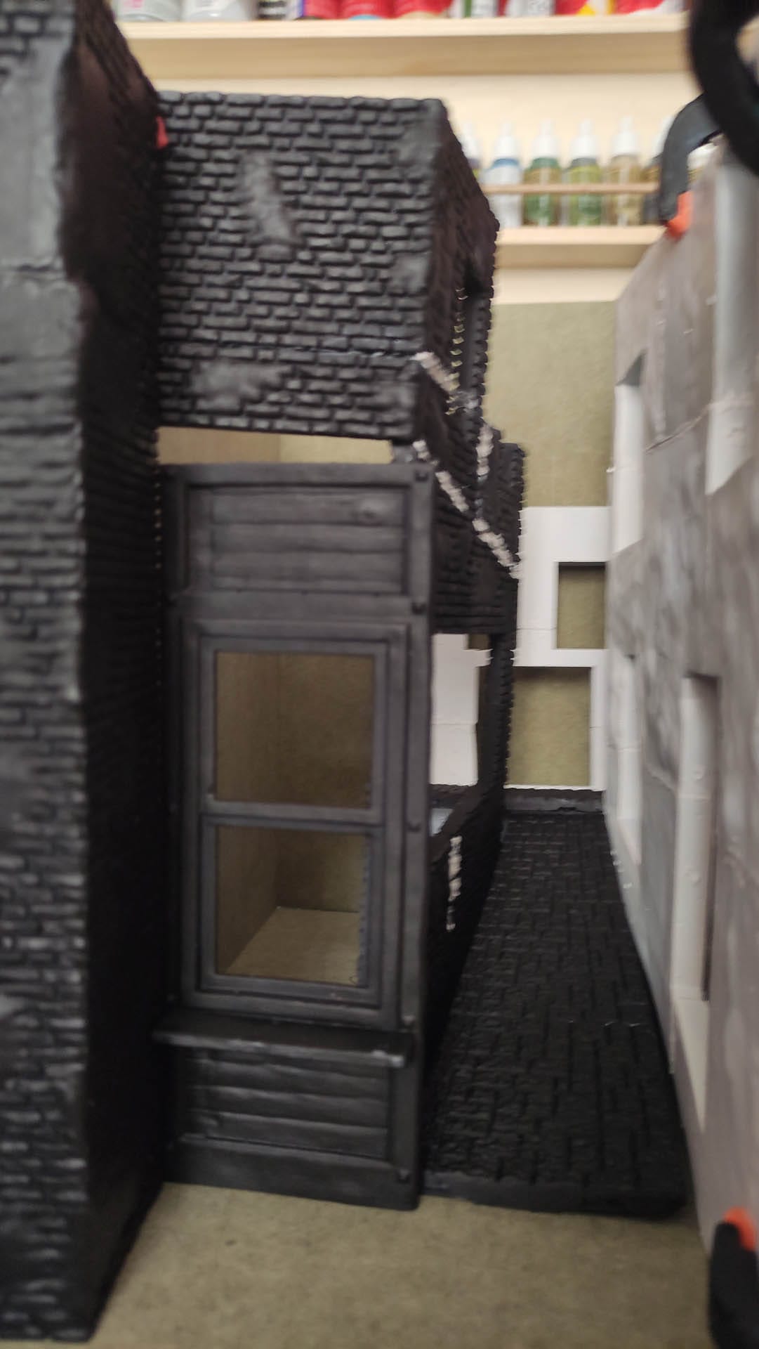 Diorama de una calle de París con fachadas de ladrillo, iluminación LED cálida y perspectiva forzada.