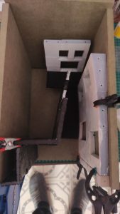 Diorama de una calle de París con fachadas de ladrillo, iluminación LED cálida y perspectiva forzada.