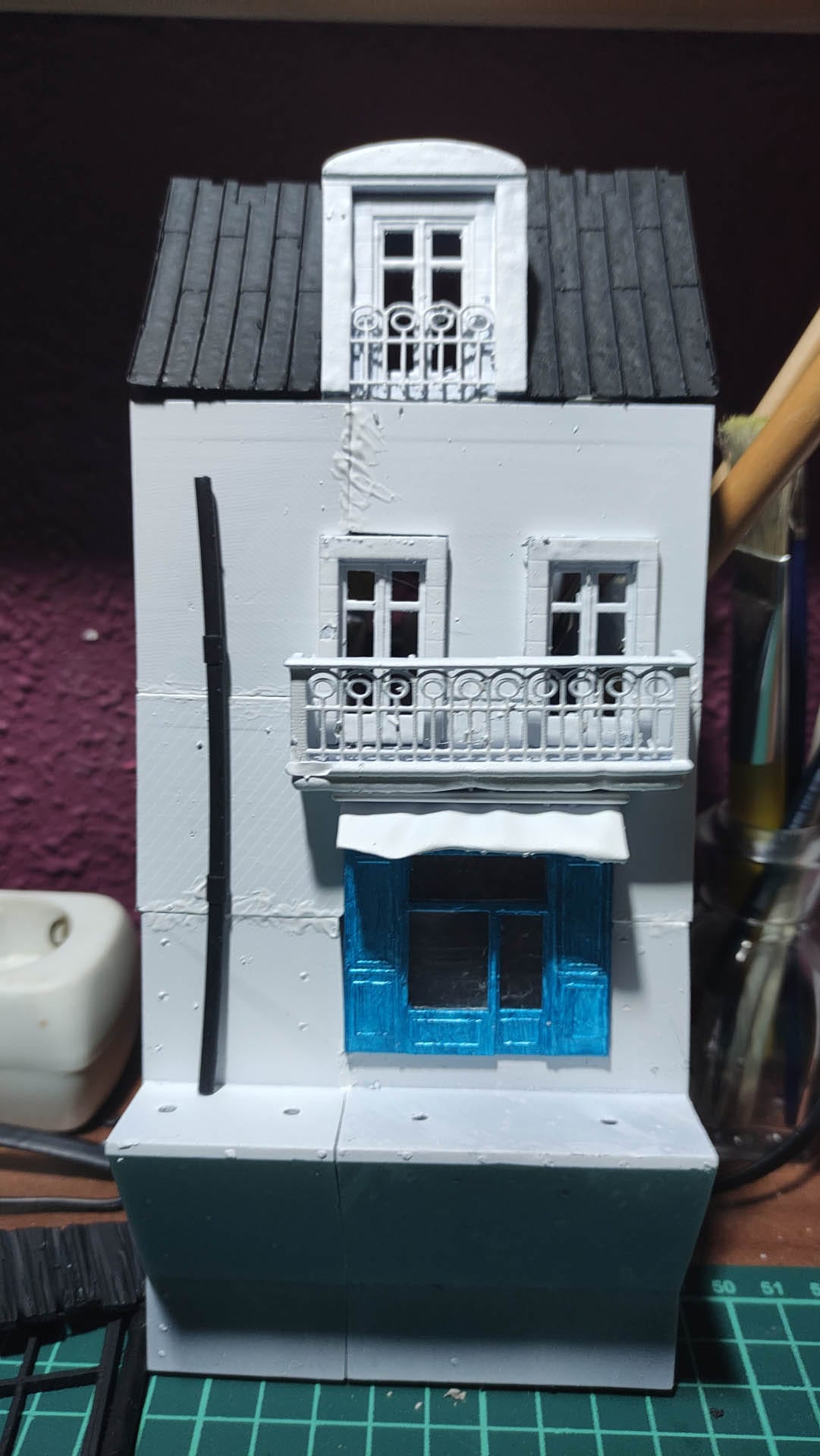 Diorama de una calle de París con fachadas de ladrillo, iluminación LED cálida y perspectiva forzada.