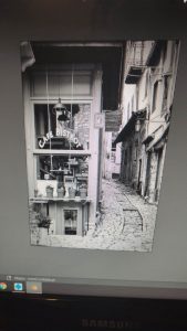 Diorama de una calle de París con fachadas de ladrillo, iluminación LED cálida y perspectiva forzada.