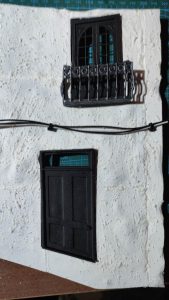 Diorama de una calle de París con fachadas de ladrillo, iluminación LED cálida y perspectiva forzada.