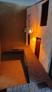 Diorama de una calle de París con fachadas de ladrillo, iluminación LED cálida y perspectiva forzada.