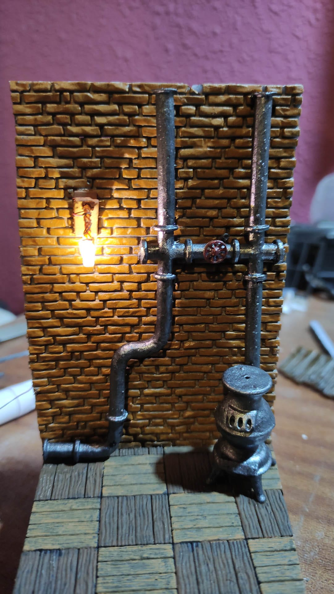 Diorama de una calle de París con fachadas de ladrillo, iluminación LED cálida y perspectiva forzada.