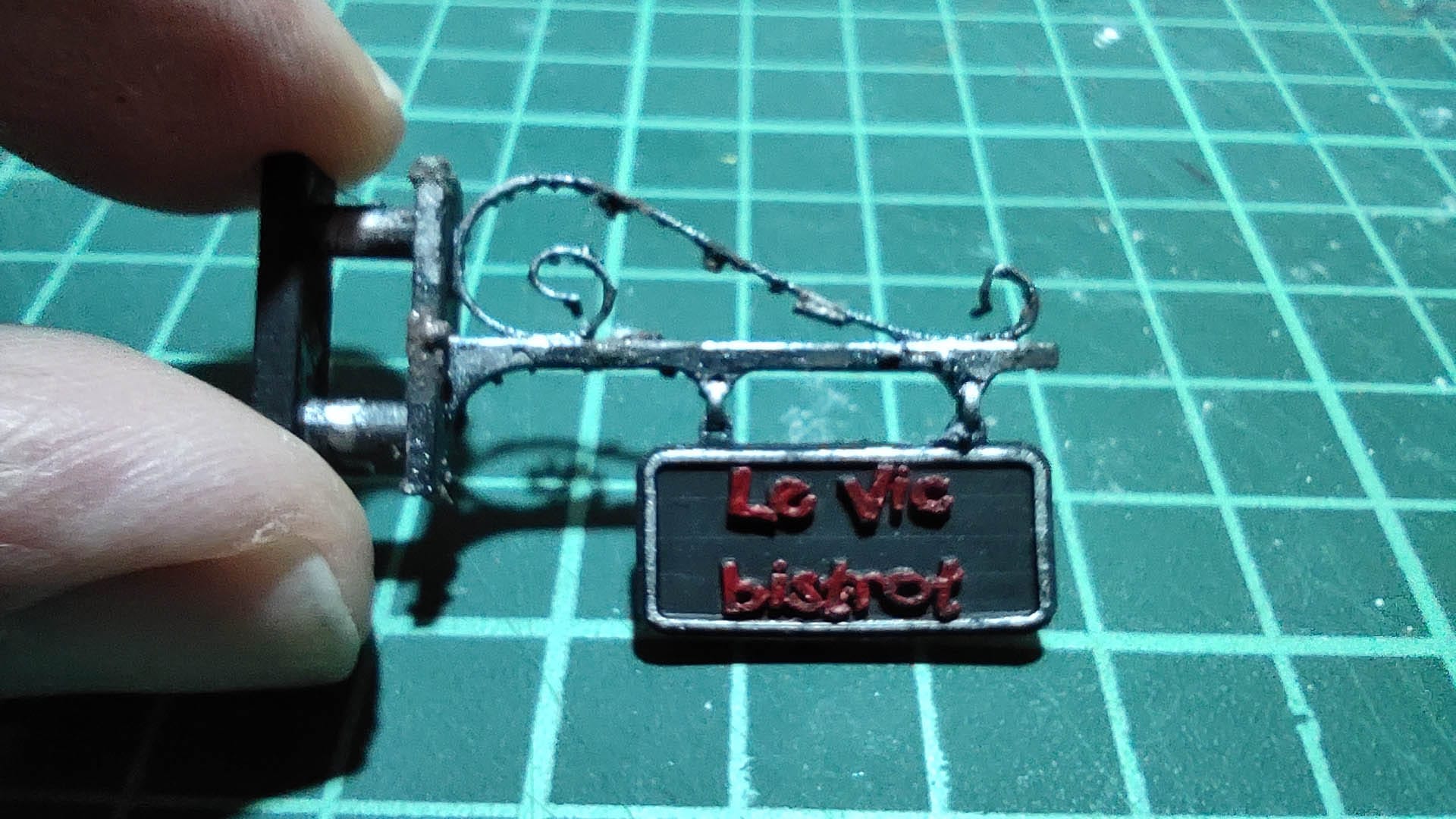 Diorama de una calle de París con fachadas de ladrillo, iluminación LED cálida y perspectiva forzada.