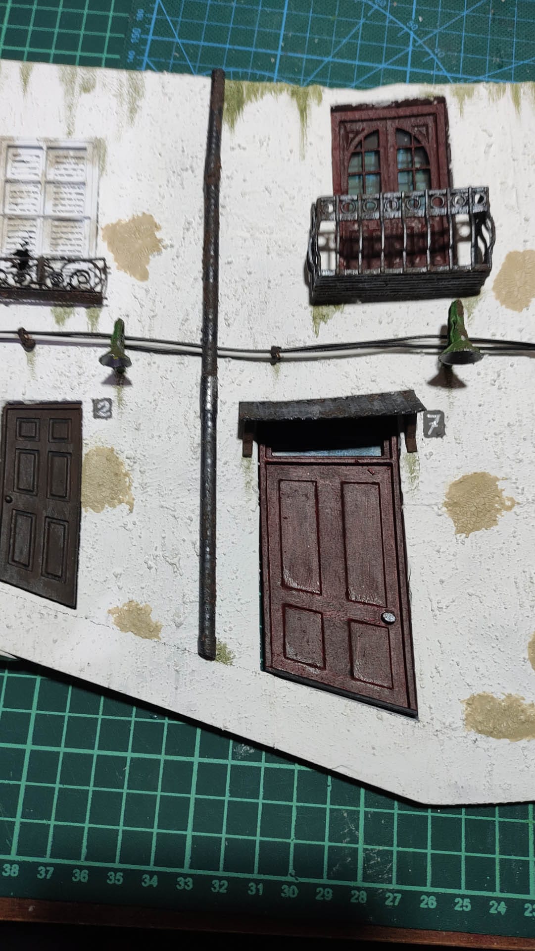 Diorama de una calle de París con fachadas de ladrillo, iluminación LED cálida y perspectiva forzada.