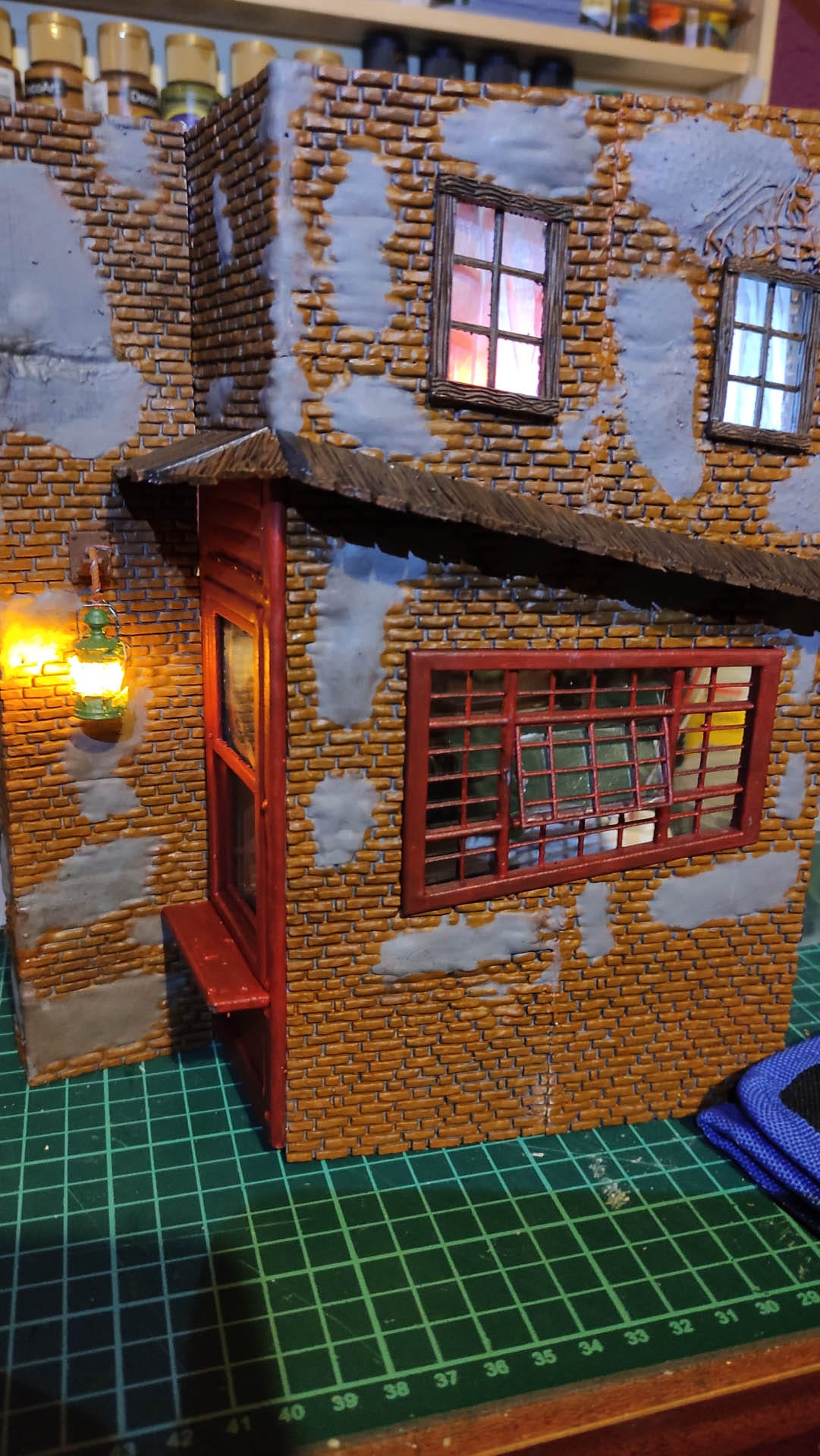 Diorama de una calle de París con fachadas de ladrillo, iluminación LED cálida y perspectiva forzada.