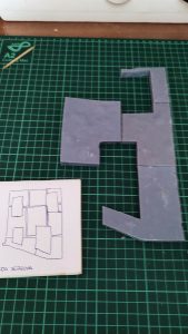 Diorama de una calle de París con fachadas de ladrillo, iluminación LED cálida y perspectiva forzada.