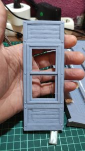 Diorama de una calle de París con fachadas de ladrillo, iluminación LED cálida y perspectiva forzada.