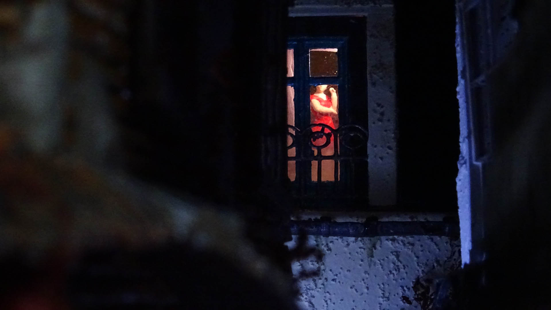 Diorama de una calle de París con fachadas de ladrillo, iluminación LED cálida y perspectiva forzada.