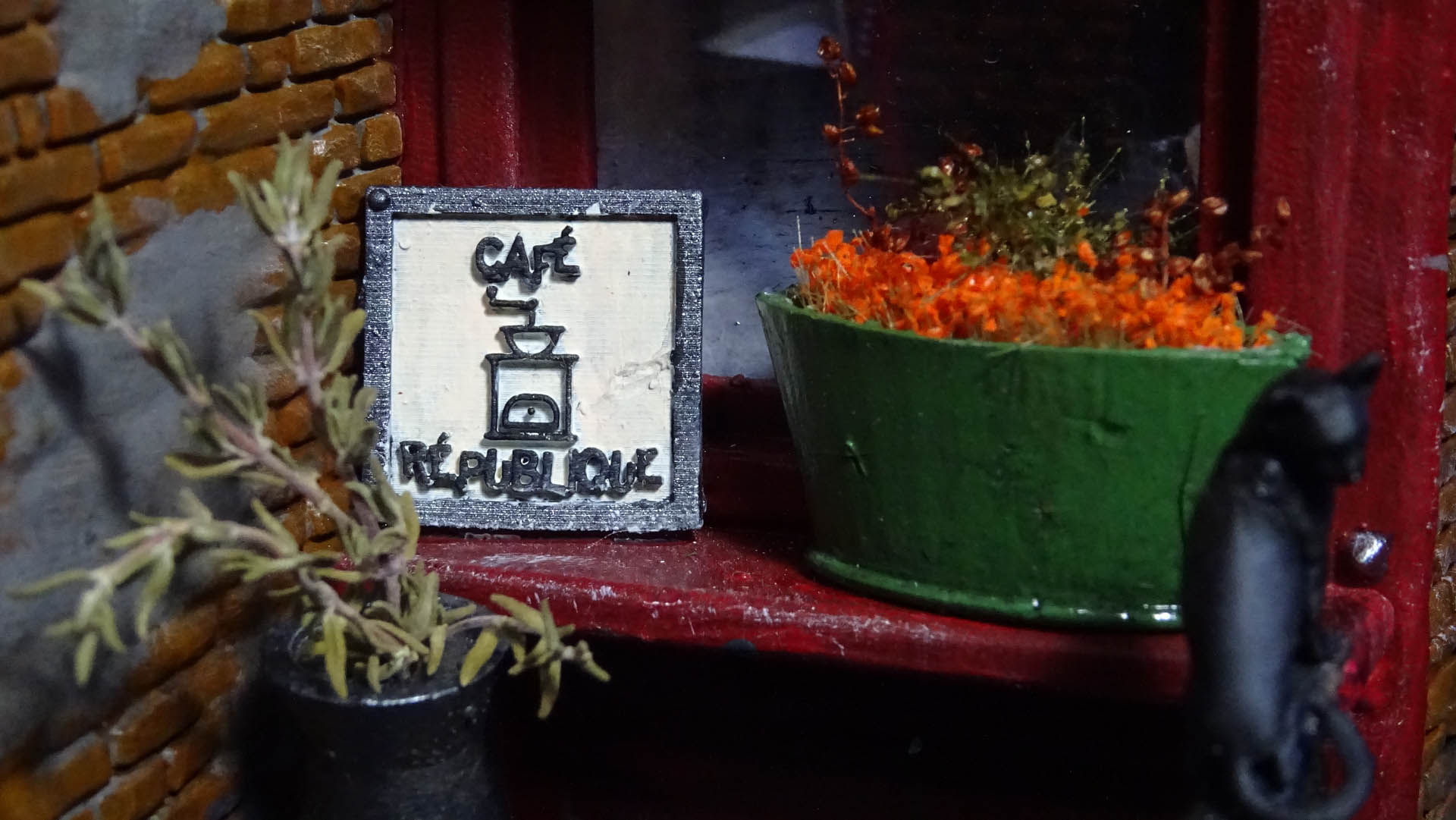 Diorama de una calle de París con fachadas de ladrillo, iluminación LED cálida y perspectiva forzada.