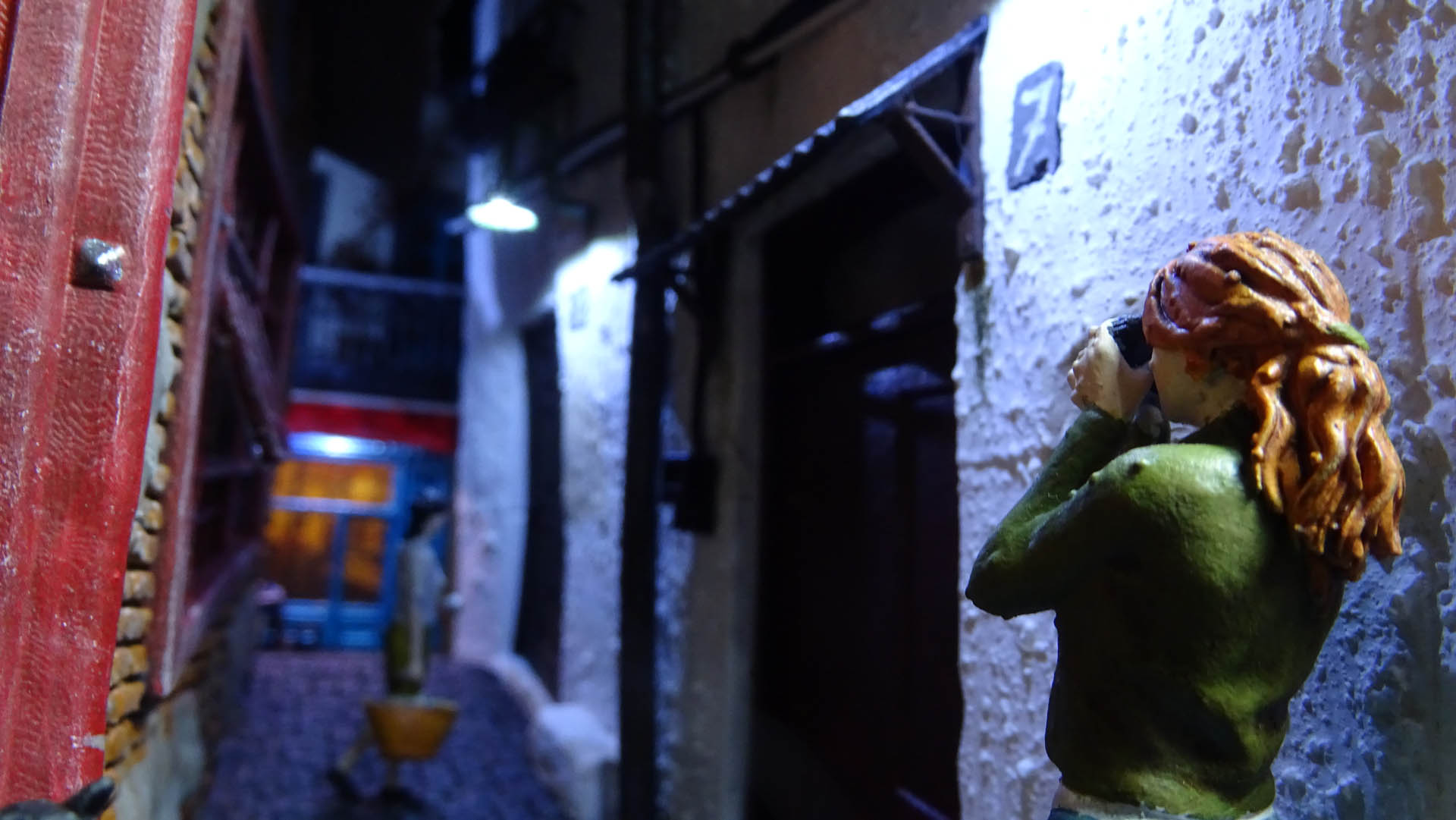Diorama de una calle de París con fachadas de ladrillo, iluminación LED cálida y perspectiva forzada.