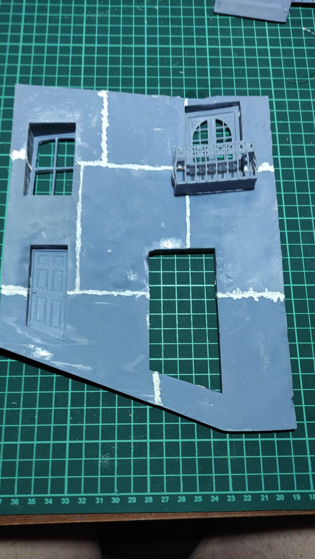 Diorama de una calle de París con fachadas de ladrillo, iluminación LED cálida y perspectiva forzada.