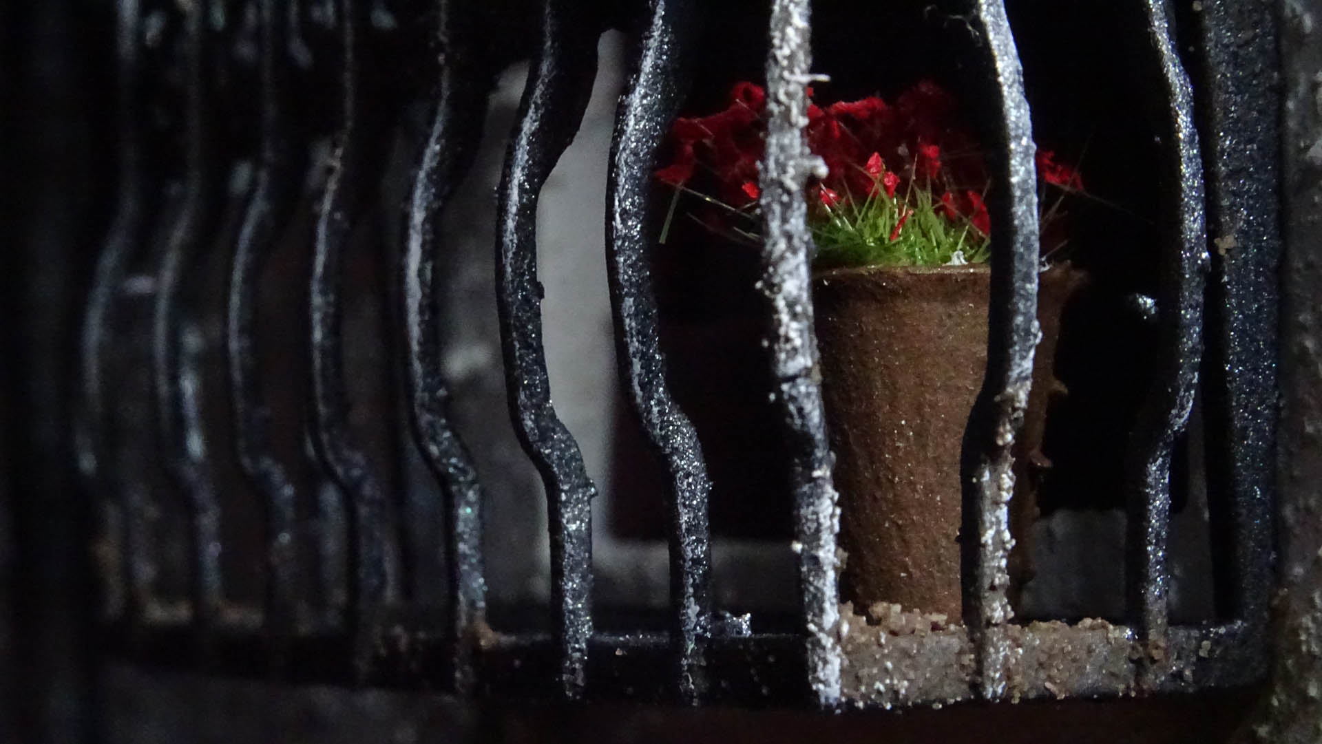 Diorama de una calle de París con fachadas de ladrillo, iluminación LED cálida y perspectiva forzada.
