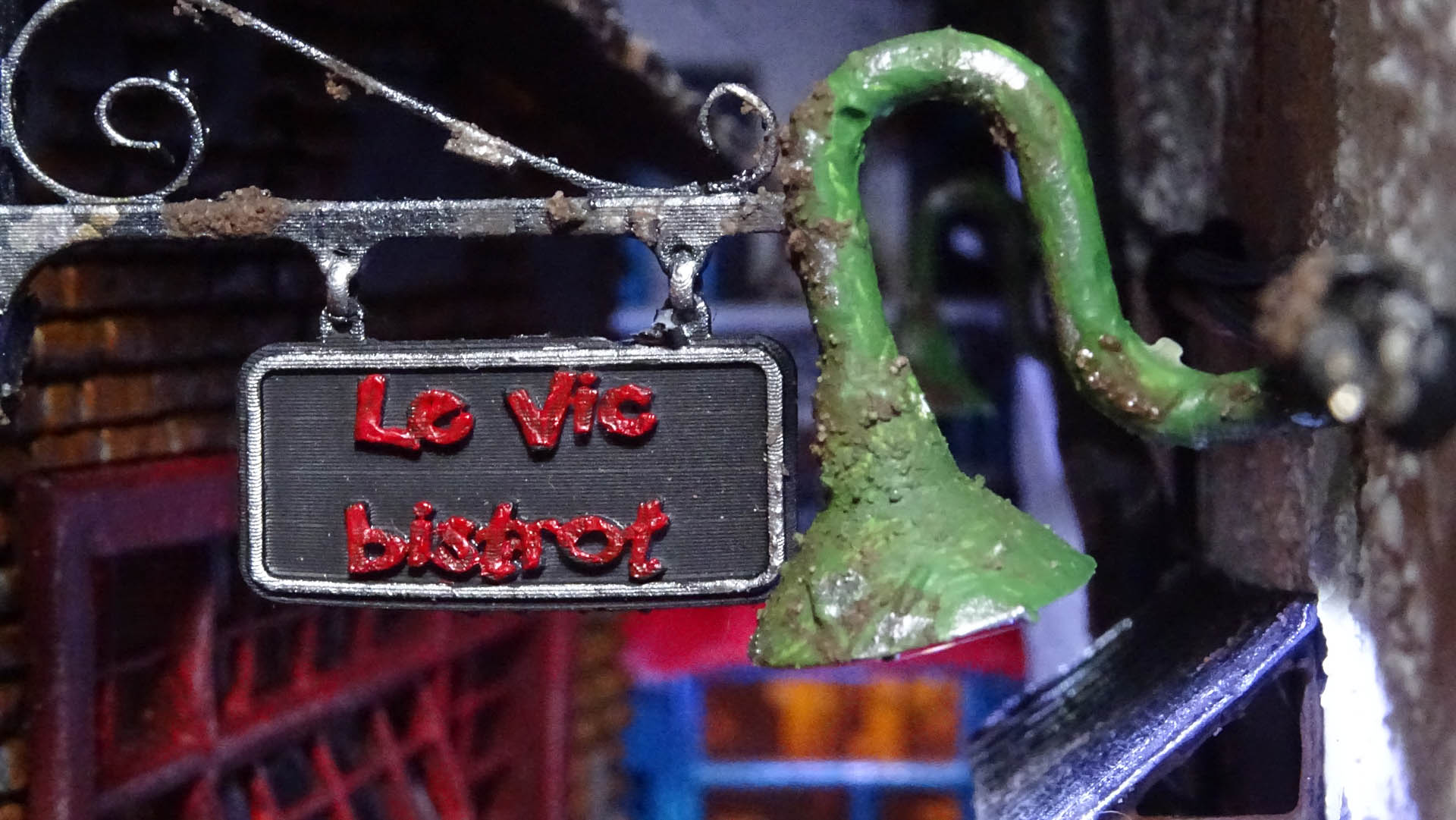 Diorama de una calle de París con fachadas de ladrillo, iluminación LED cálida y perspectiva forzada.