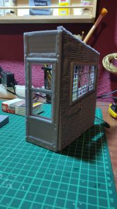 Diorama de una calle de París con fachadas de ladrillo, iluminación LED cálida y perspectiva forzada.