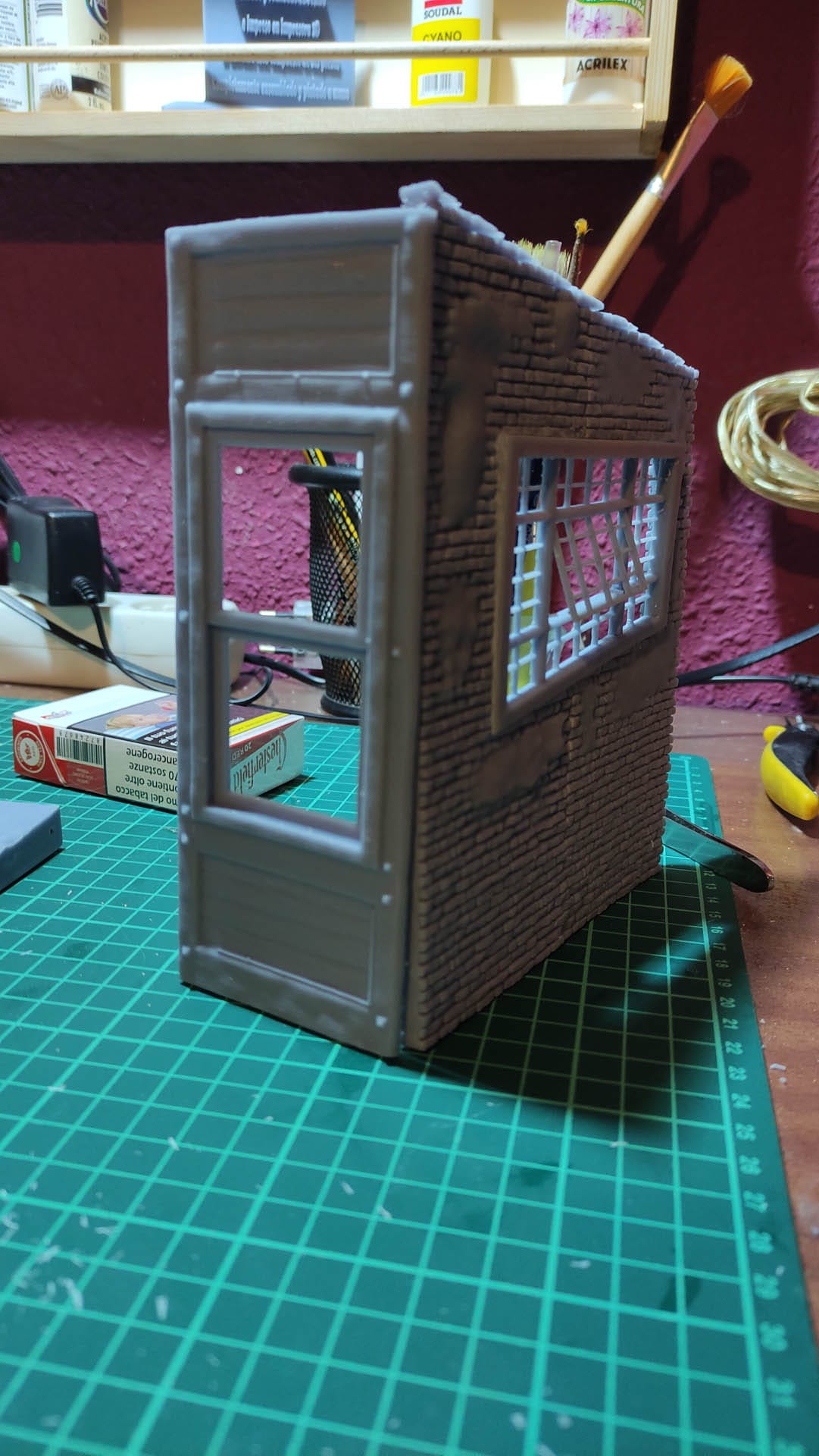 Diorama de una calle de París con fachadas de ladrillo, iluminación LED cálida y perspectiva forzada.