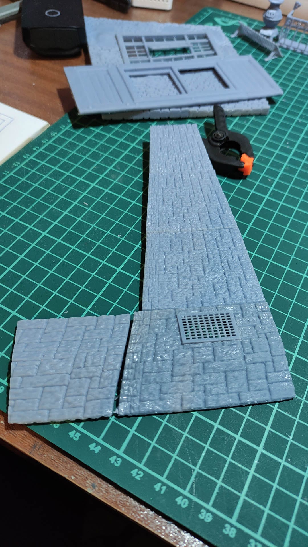 Diorama de una calle de París con fachadas de ladrillo, iluminación LED cálida y perspectiva forzada.