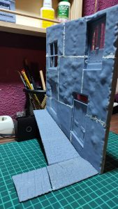 Diorama de una calle de París con fachadas de ladrillo, iluminación LED cálida y perspectiva forzada.