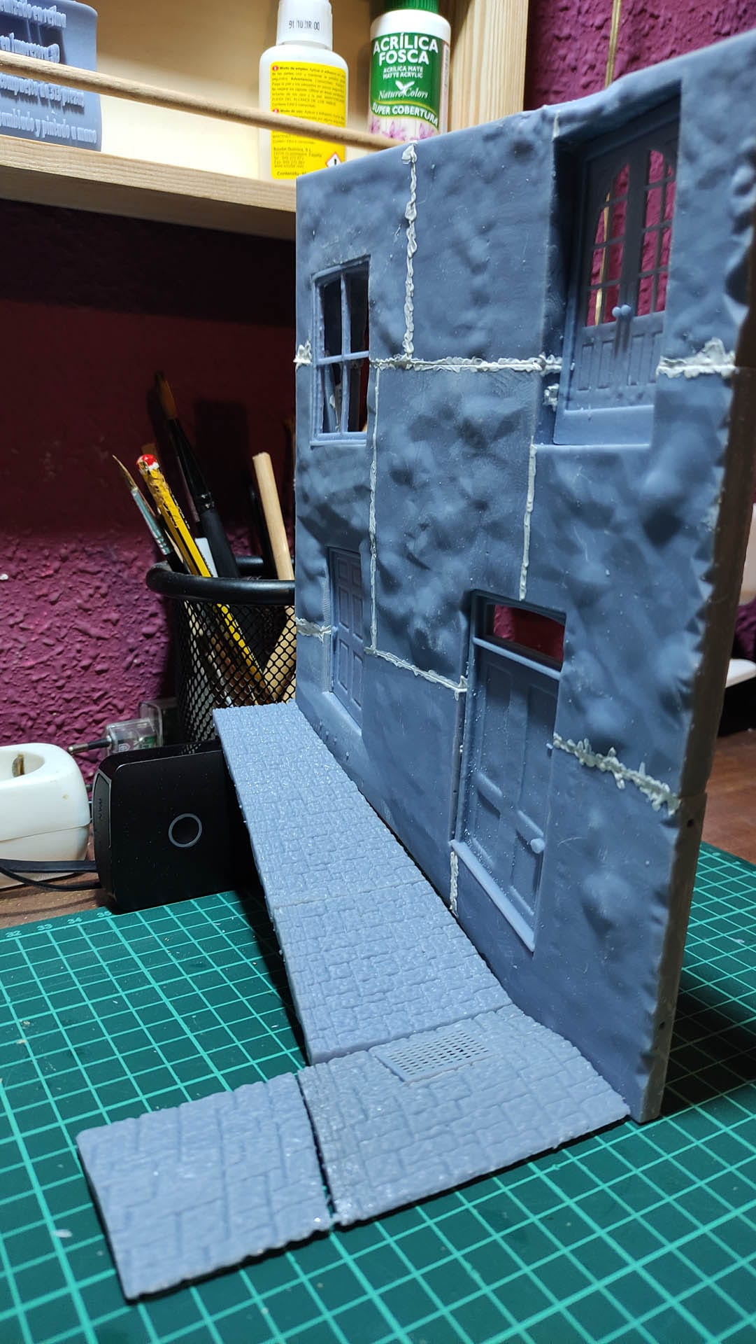 Diorama de una calle de París con fachadas de ladrillo, iluminación LED cálida y perspectiva forzada.