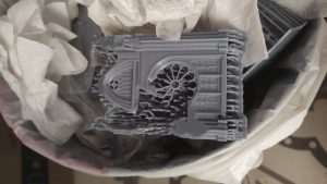 Pieza de resina fallida descartada en la papelera tras un error en el laminado de la impresora 3D