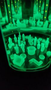 Proceso de curado de piezas de resina UV bajo luz ultravioleta en el taller