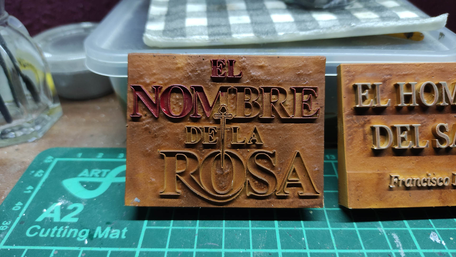 Placa decorativa hecha a mano para exposición del diorama El Nombre de la Rosa
