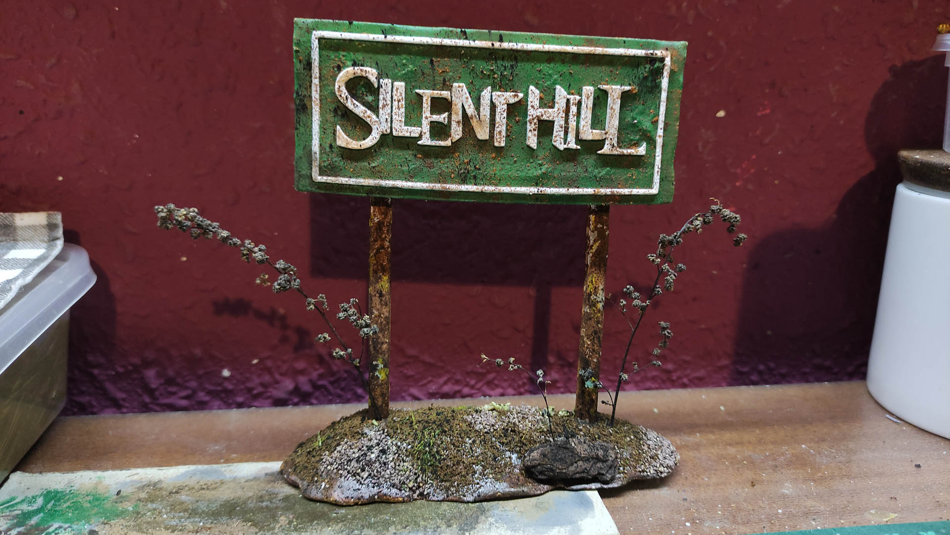 Cartel oxidado en miniatura inspirado en Silent Hill para escenografía de terror