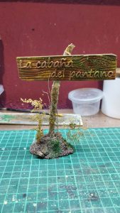 Cartel artesanal en miniatura de madera para el diorama La Cabaña del Pantano de 27 Dioramas