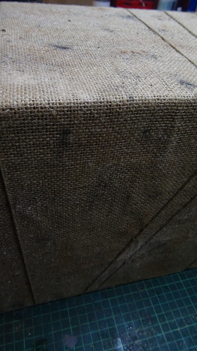 Exterior del diorama tipo El hmbre del saco, forrado en tela de arpillera y cuerda, diseño rústico para estantería.