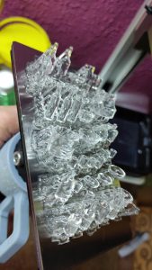 Diorama artístico de una cabaña de madera azul envejecida sobre pilotes en un pantano, con efectos de agua estancada, un bote de remos y detalles de vegetación pantanosa.