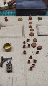 Diorama artístico de una cabaña de madera azul envejecida sobre pilotes en un pantano, con efectos de agua estancada, un bote de remos y detalles de vegetación pantanosa.