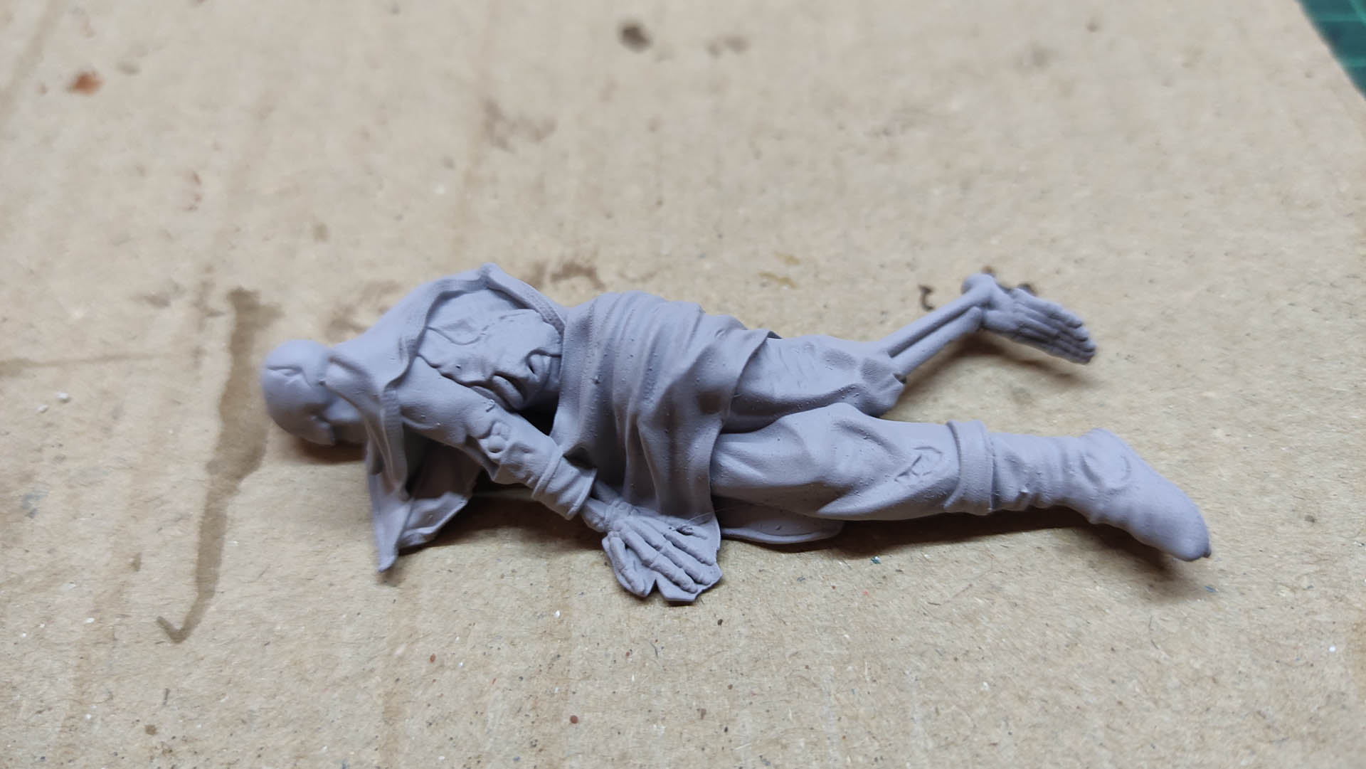 Diorama artístico de una cabaña de madera azul envejecida sobre pilotes en un pantano, con efectos de agua estancada, un bote de remos y detalles de vegetación pantanosa.