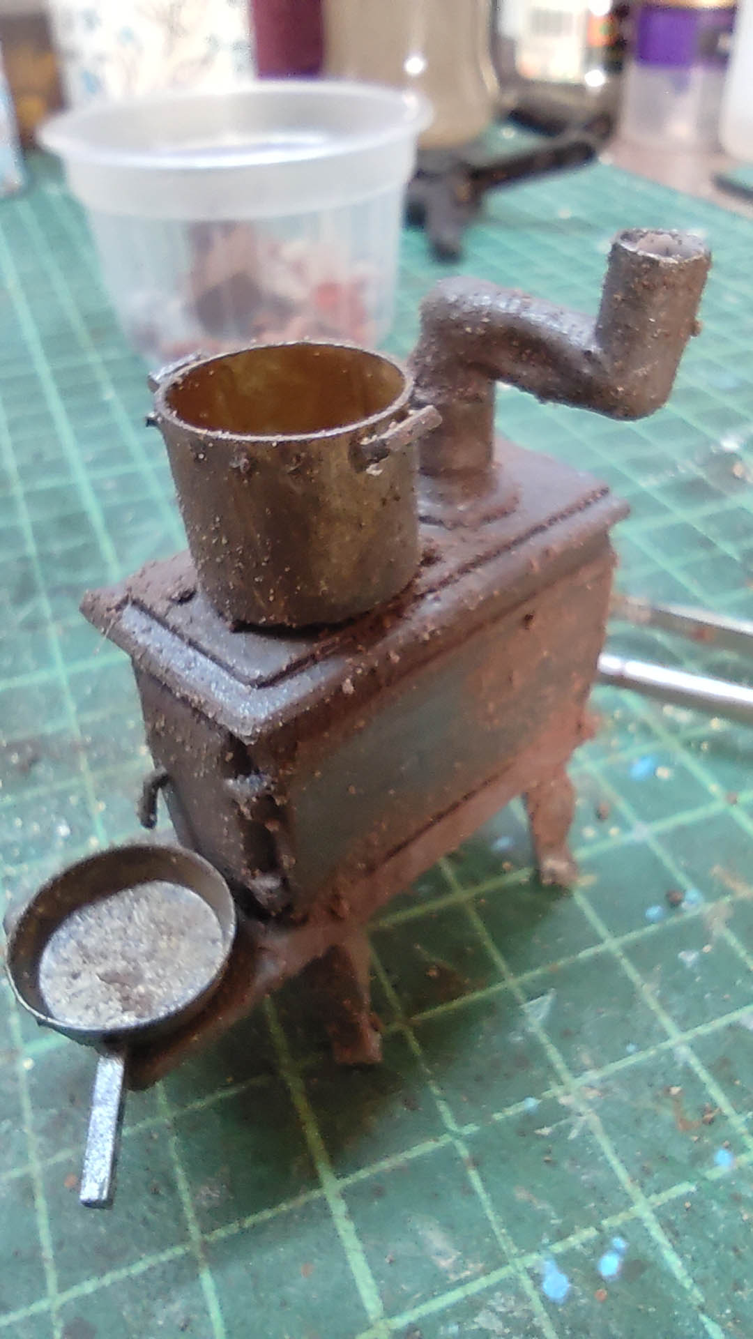 Diorama artístico de una cabaña de madera azul envejecida sobre pilotes en un pantano, con efectos de agua estancada, un bote de remos y detalles de vegetación pantanosa.