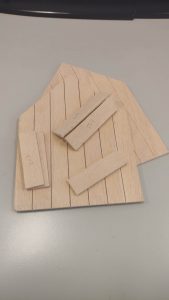 Diorama artístico de una cabaña de madera azul envejecida sobre pilotes en un pantano, con efectos de agua estancada, un bote de remos y detalles de vegetación pantanosa.