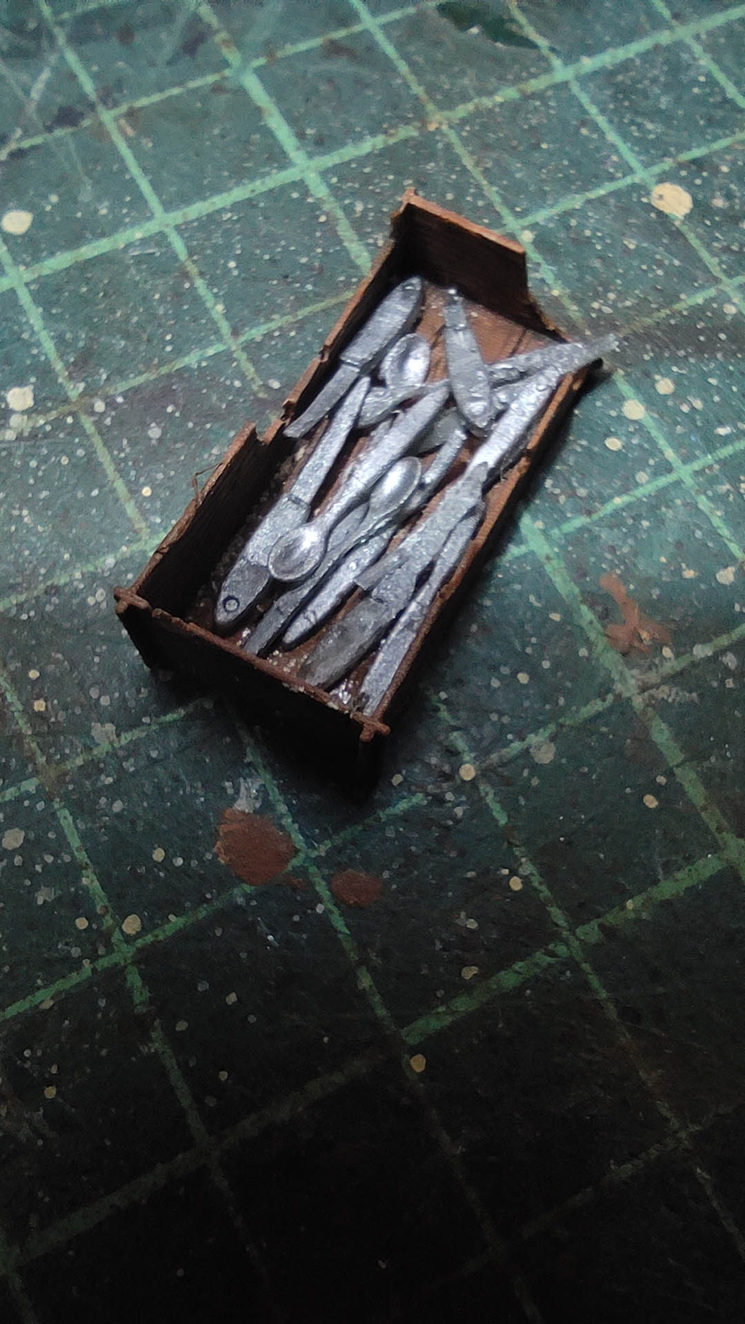 Diorama artístico de una cabaña de madera azul envejecida sobre pilotes en un pantano, con efectos de agua estancada, un bote de remos y detalles de vegetación pantanosa.