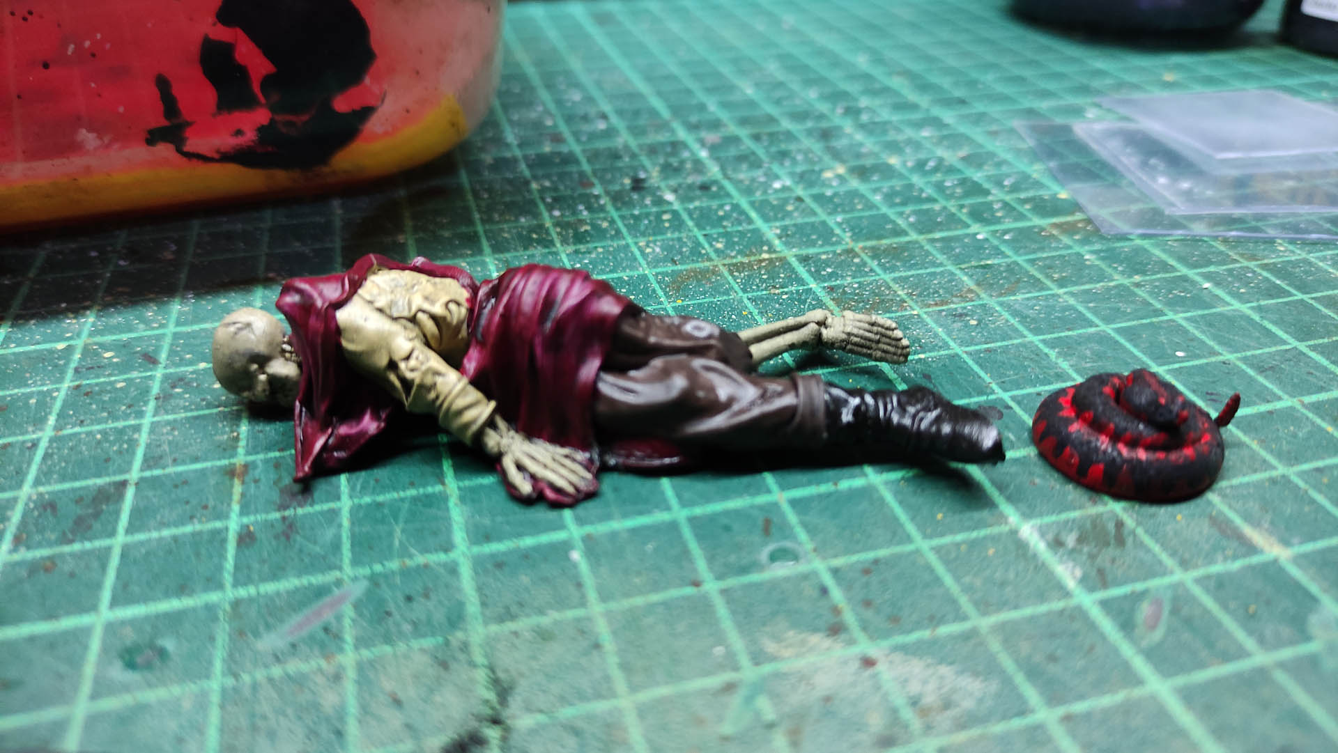 Diorama artístico de una cabaña de madera azul envejecida sobre pilotes en un pantano, con efectos de agua estancada, un bote de remos y detalles de vegetación pantanosa.