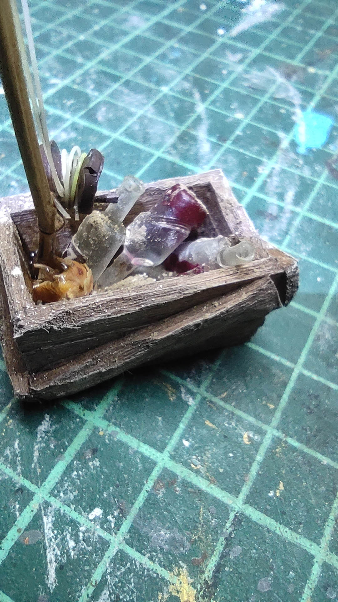 Diorama artístico de una cabaña de madera azul envejecida sobre pilotes en un pantano, con efectos de agua estancada, un bote de remos y detalles de vegetación pantanosa.