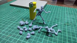 Diorama artesanal detallado de un duende y un pozo estructurado en tres niveles. El nivel superior recrea un jardín exterior exuberante utilizando vegetación natural y preservada (musgos y enredaderas), sobre estancias subterráneas de piedra y madera