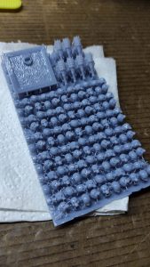 Diorama artesanal detallado de un duende y un pozo estructurado en tres niveles. El nivel superior recrea un jardín exterior exuberante utilizando vegetación natural y preservada (musgos y enredaderas), sobre estancias subterráneas de piedra y madera