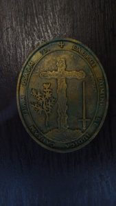 Diorama artesanal detallado de un duende y un pozo estructurado en tres niveles. El nivel superior recrea un jardín exterior exuberante utilizando vegetación natural y preservada (musgos y enredaderas), sobre estancias subterráneas de piedra y madera