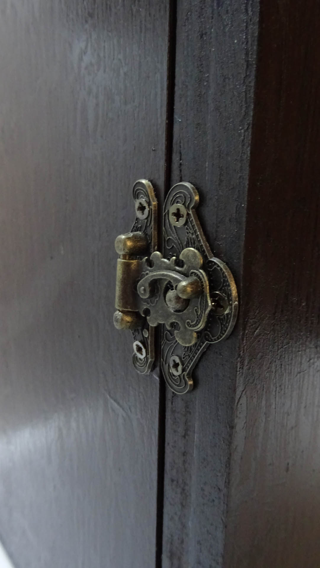 Diorama artesanal detallado de un duende y un pozo estructurado en tres niveles. El nivel superior recrea un jardín exterior exuberante utilizando vegetación natural y preservada (musgos y enredaderas), sobre estancias subterráneas de piedra y madera