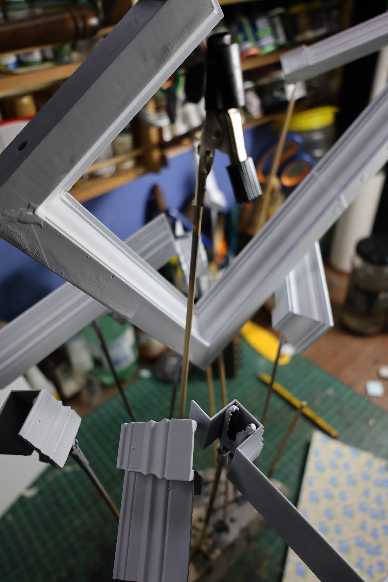 Proceso de construcción del diorama "Las Gemelas": recreación artesanal del pasillo del hotel Overlook con papel pintado geométrico en miniatura, carpintería detallada de puertas de hotel