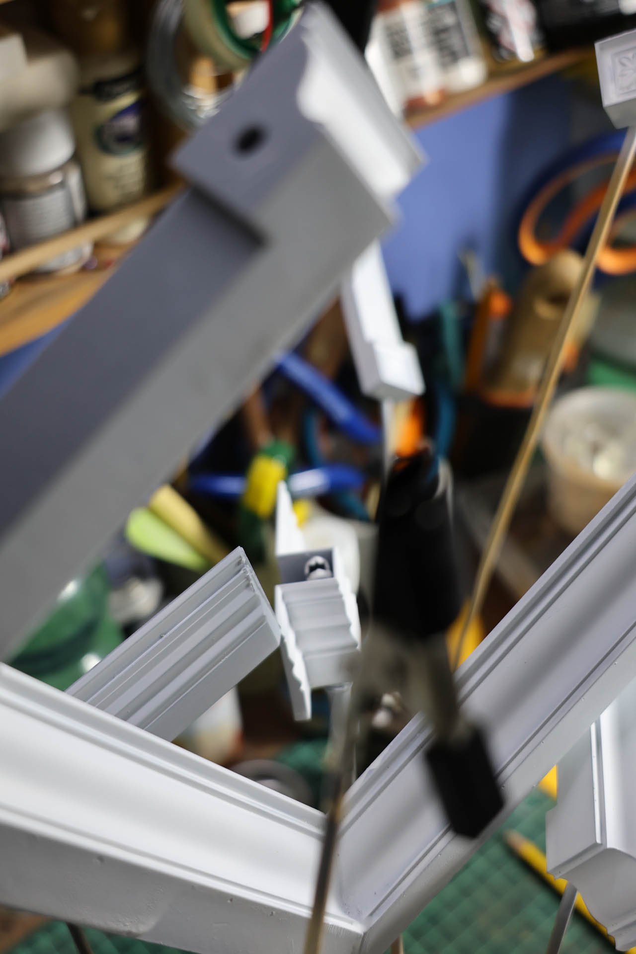 Proceso de construcción del diorama "Las Gemelas": recreación artesanal del pasillo del hotel Overlook con papel pintado geométrico en miniatura, carpintería detallada de puertas de hotel